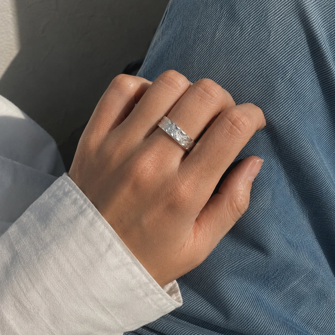 Adjustable_ring_in_gold_plated_silver_with_handcrafted_deisgn_at_front_angle_on_soft_fabric_background