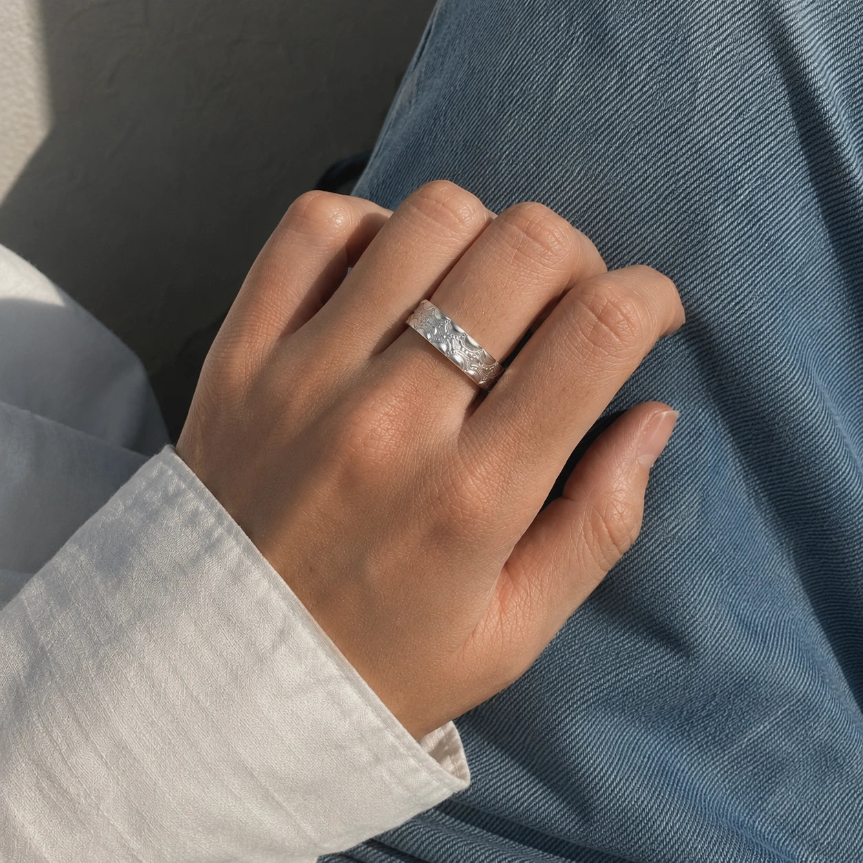 Adjustable_ring_in_sterling_silver_with_handcrafted_deisgn_worn_by_a_model