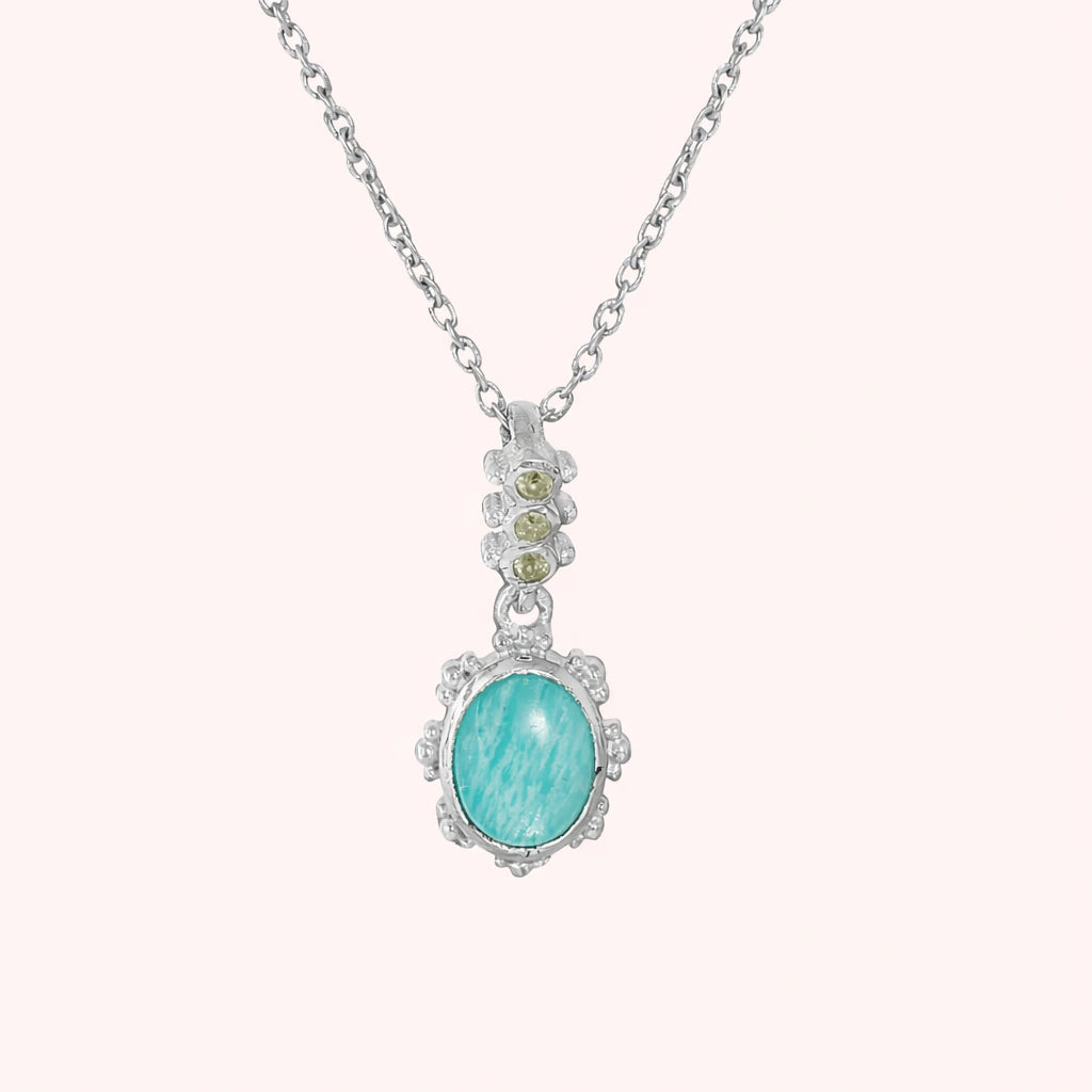 Amazonite_necklace_with_oval_blue_green_stone_sterling_silver_pendant_shown_in_front_angle_view_on_solid_pink_background
