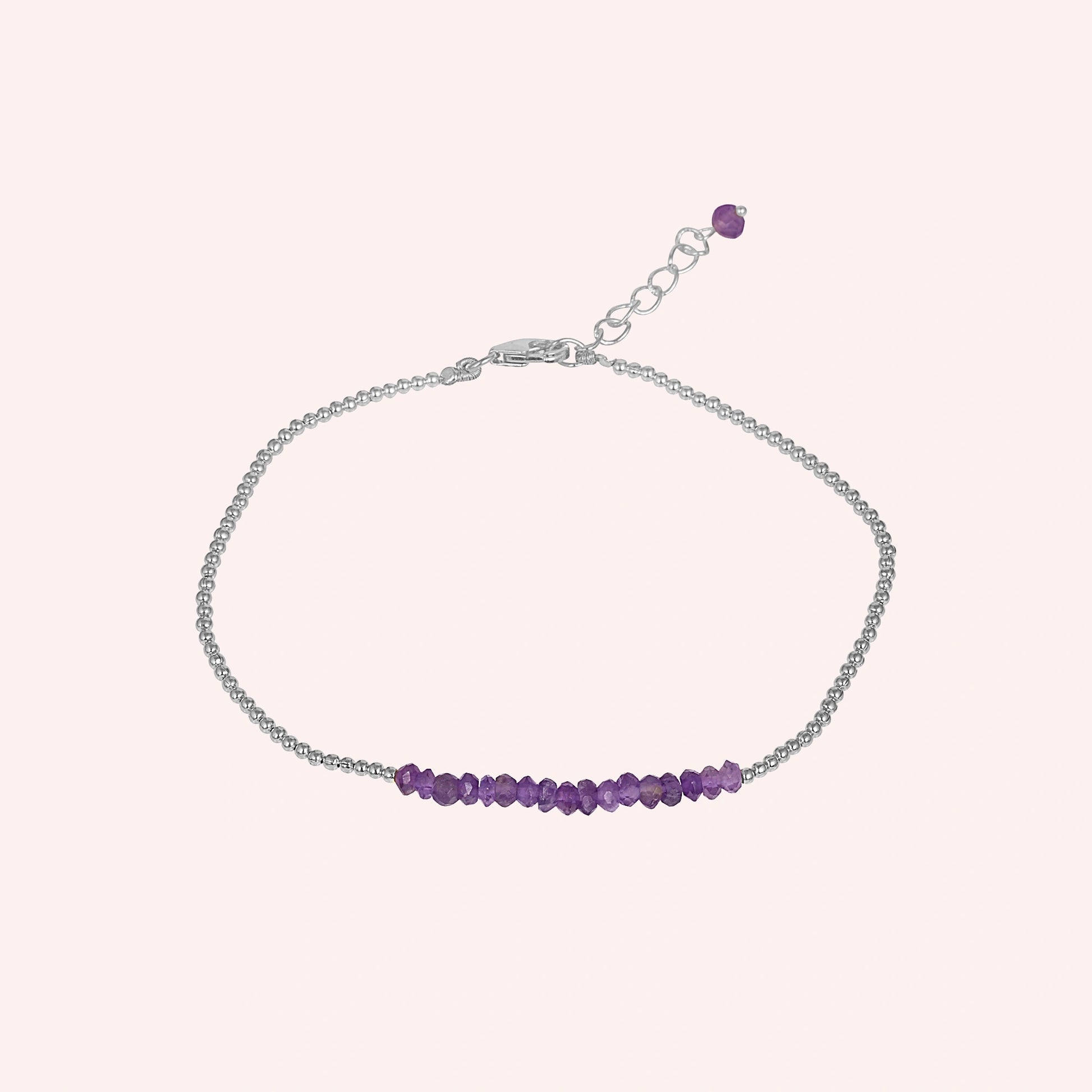 top_angle_amethyst_bracelet_with_amethyst_beads_bracelet_on_silver_chain_displayed_on_soft_blush_background