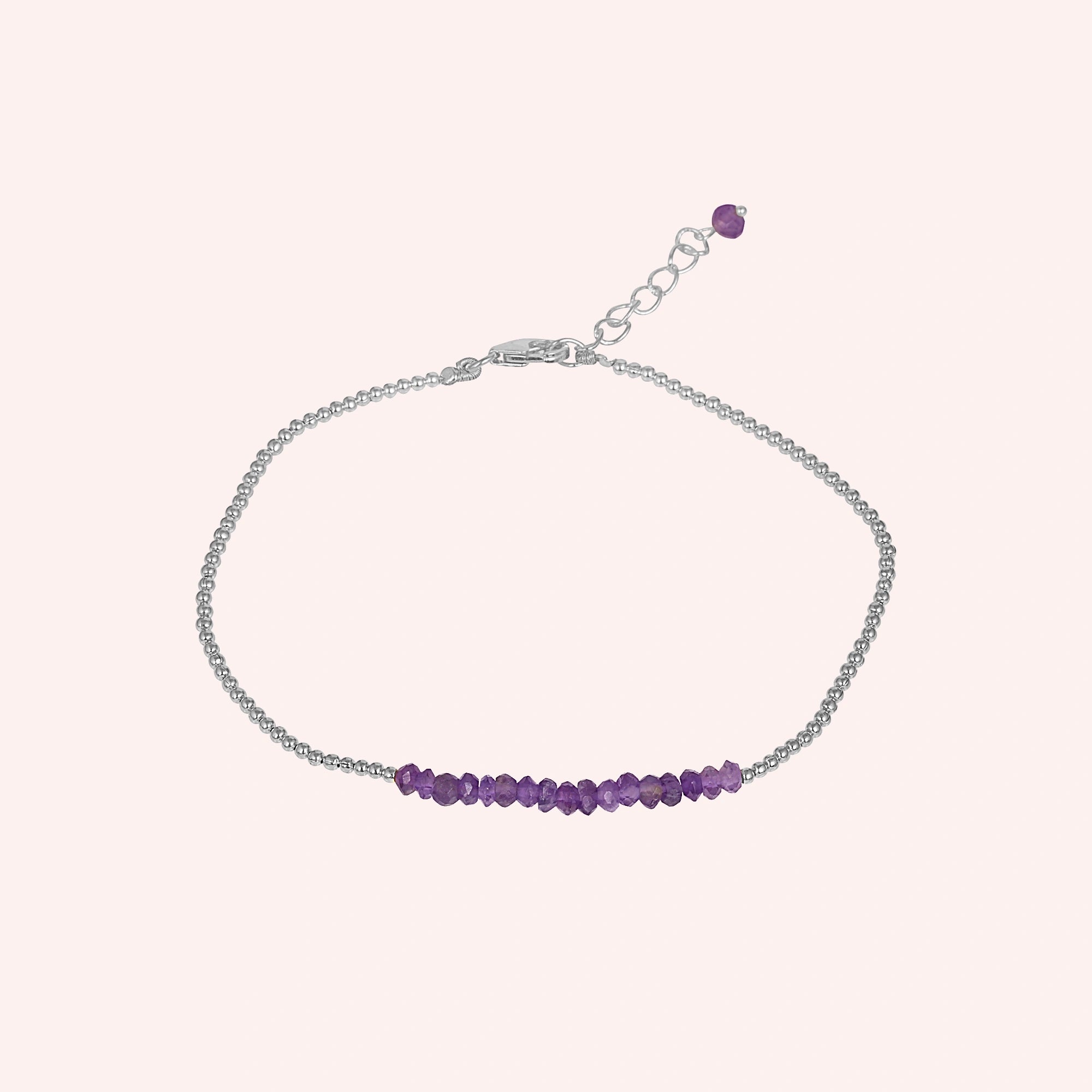 top_angle_amethyst_bracelet_with_amethyst_beads_bracelet_on_silver_chain_displayed_on_soft_blush_background