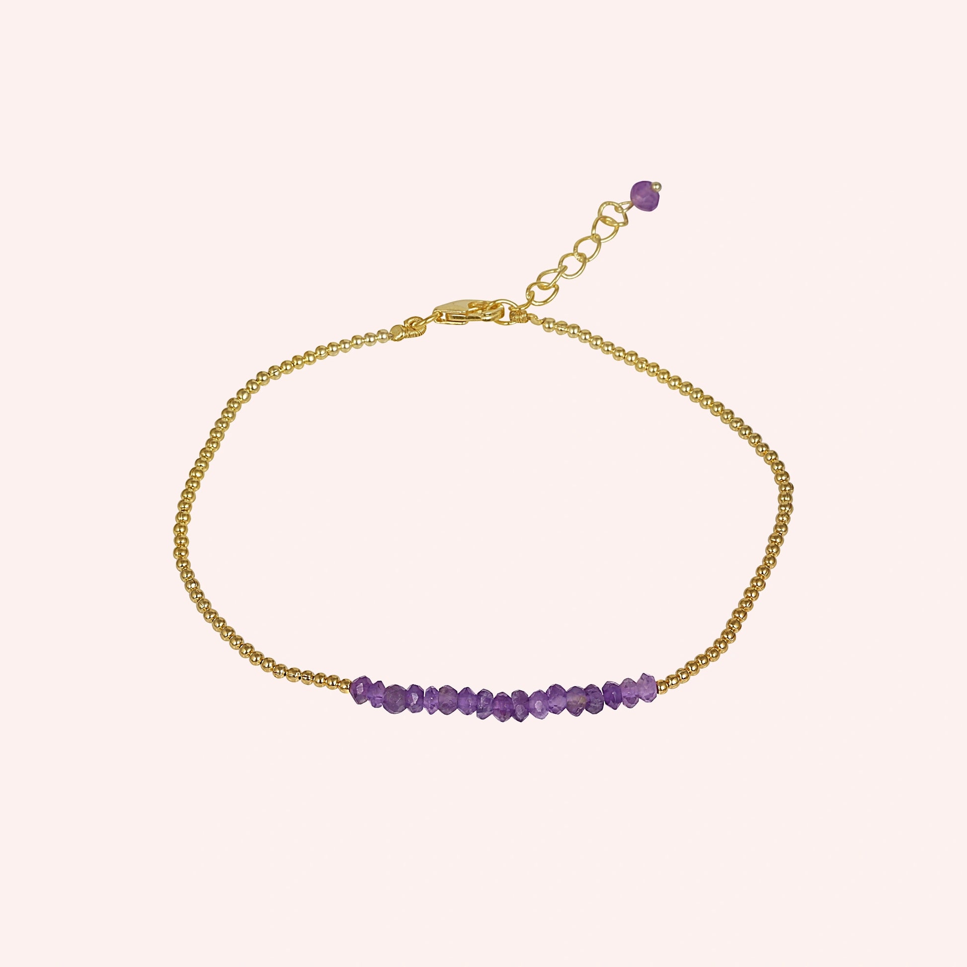 top_angle_amethyst_bracelet_with_amethyst_beads_bracelet_gold_plated_chain_centered_on_soft_pink_background