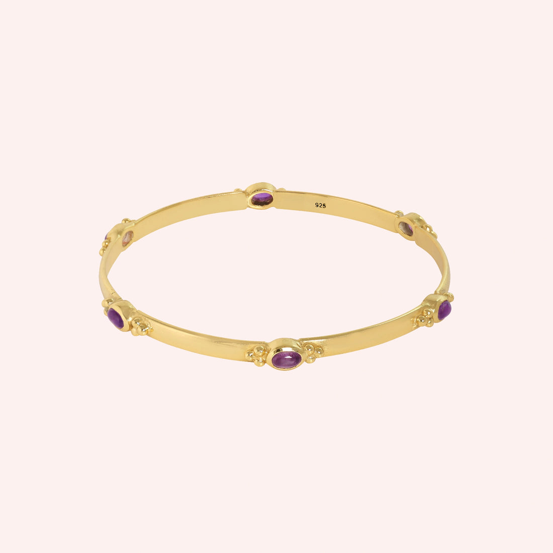 Amethyst_bracelet_in_gold_plated_silver_with_oval_amethyst_stones_at_front_angle_view_on_solid_pink_background