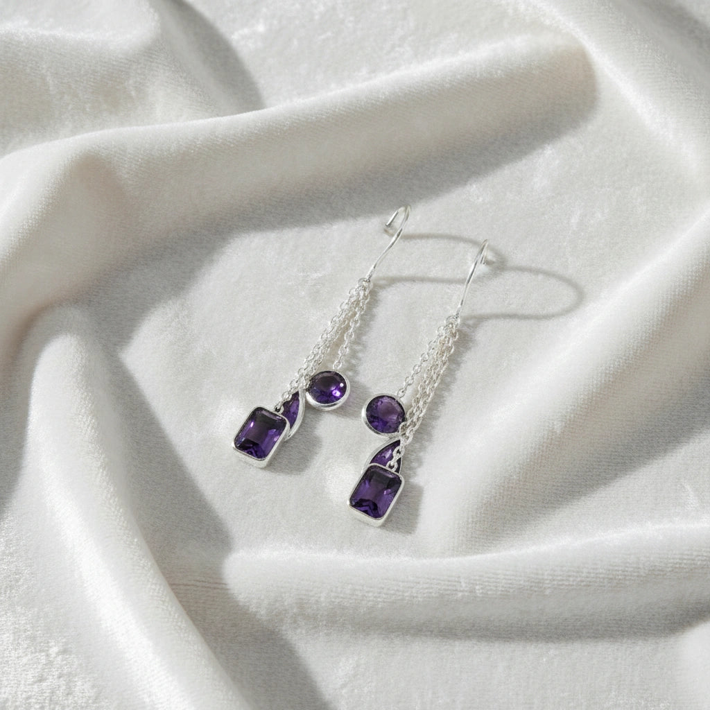boho_earrings_top_angle_chain_drop_amethyst_earrings_in_sterling_silver_resting_on_white_silk_background_soft_texture_shine