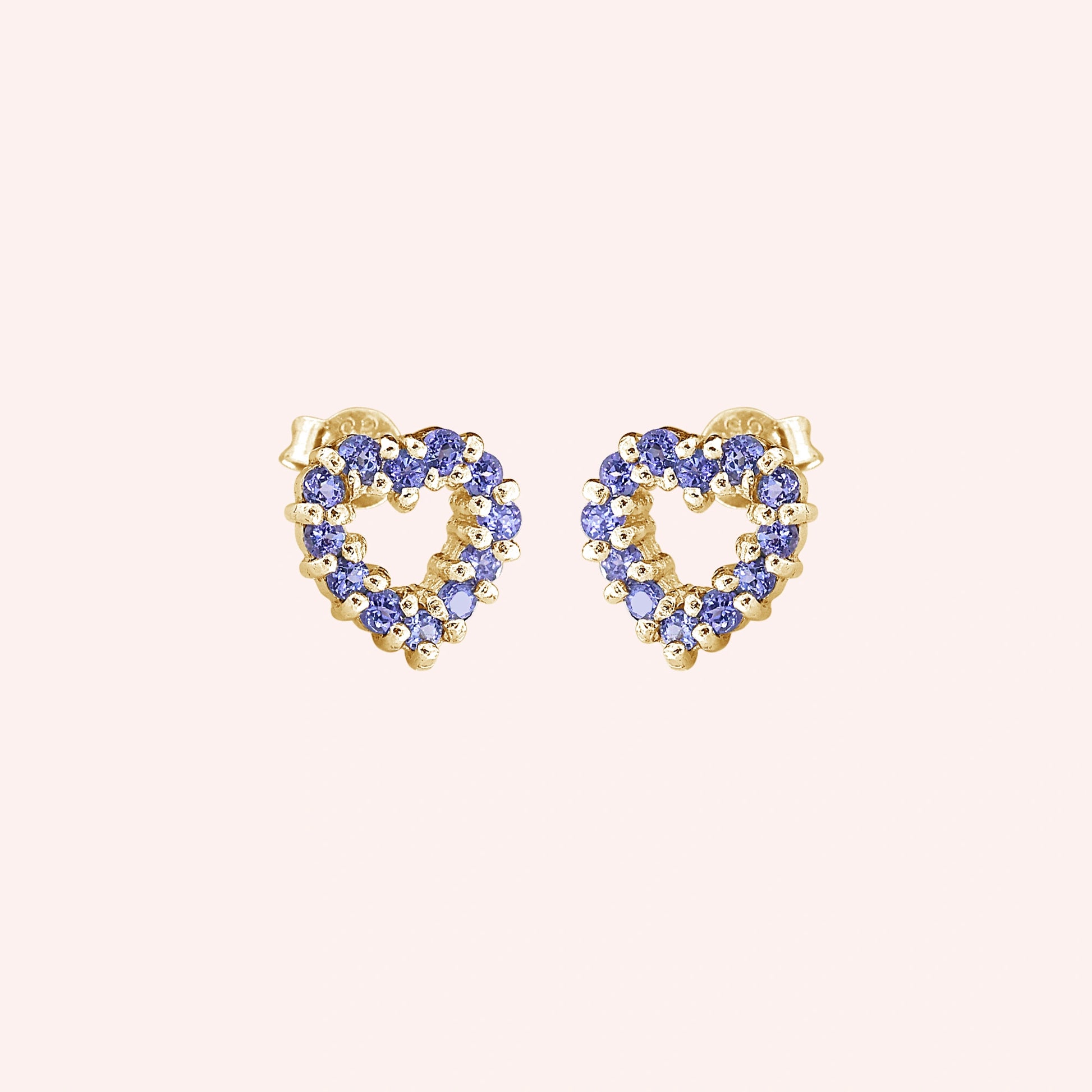 Amethyst_earrings_in_gold_plated_silver_heart_shape_with_amethyst_stones_at_a_slight_angle_view_on_solid_pink_background