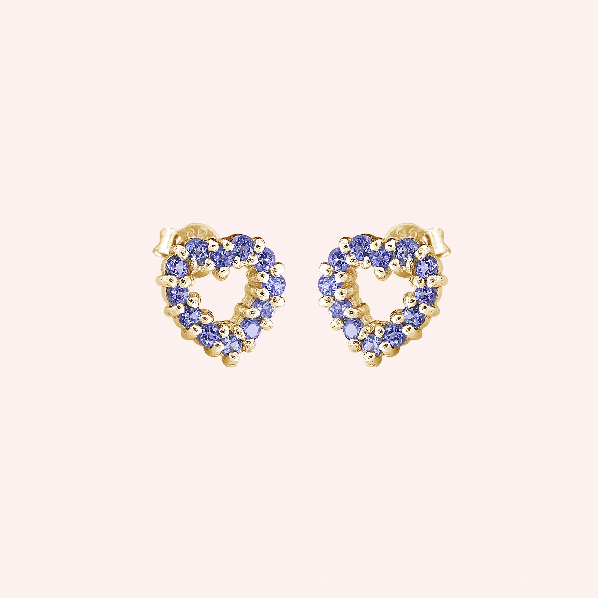 Amethyst_earrings_in_gold_plated_silver_heart_shape_with_amethyst_stones_at_a_slight_angle_view_on_solid_pink_background