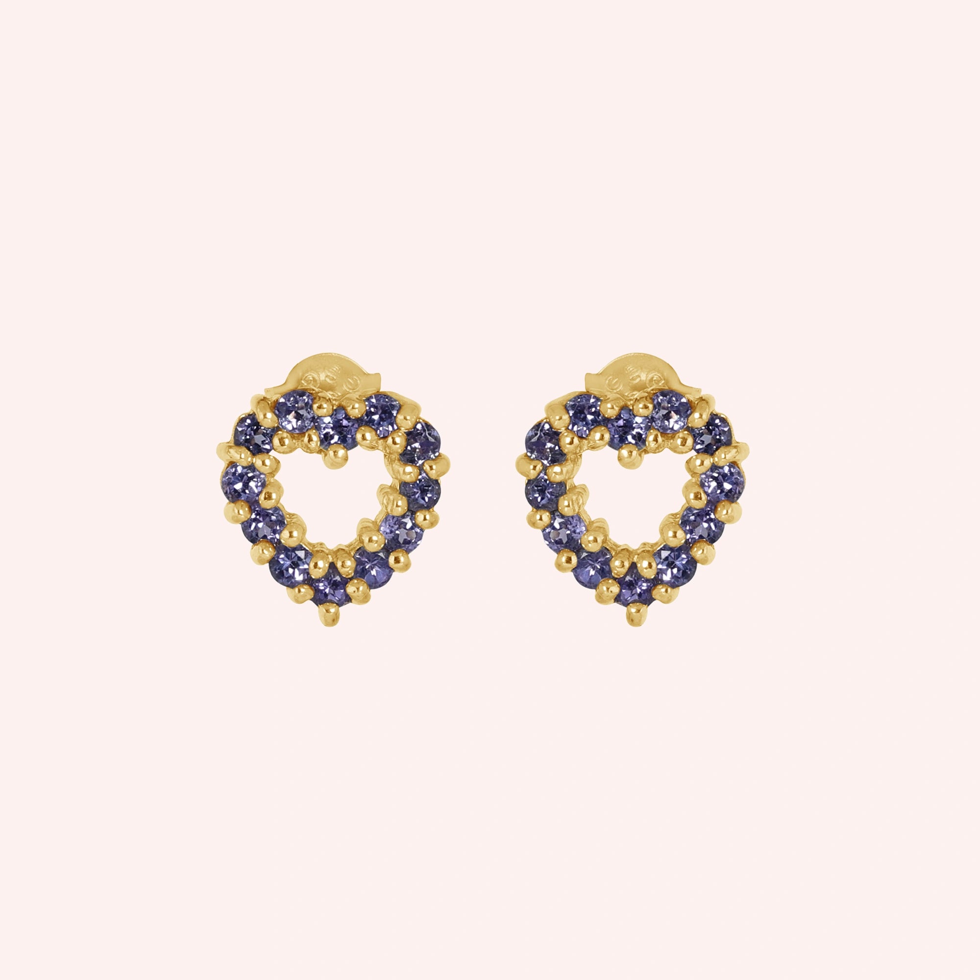 Amethyst_earrings_in_gold_plated_silver_heart_shape_with_amethyst_stones_at_a_front_angle_view_on_solid_pink_background
