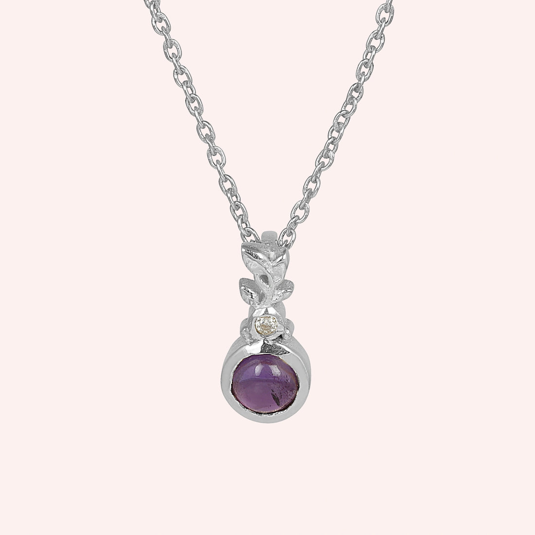 Amethyst_necklace_in_gold_plated_silver_with_amethyst_and_crystal_stones_at_front_angle_view_on_solid_pink_background