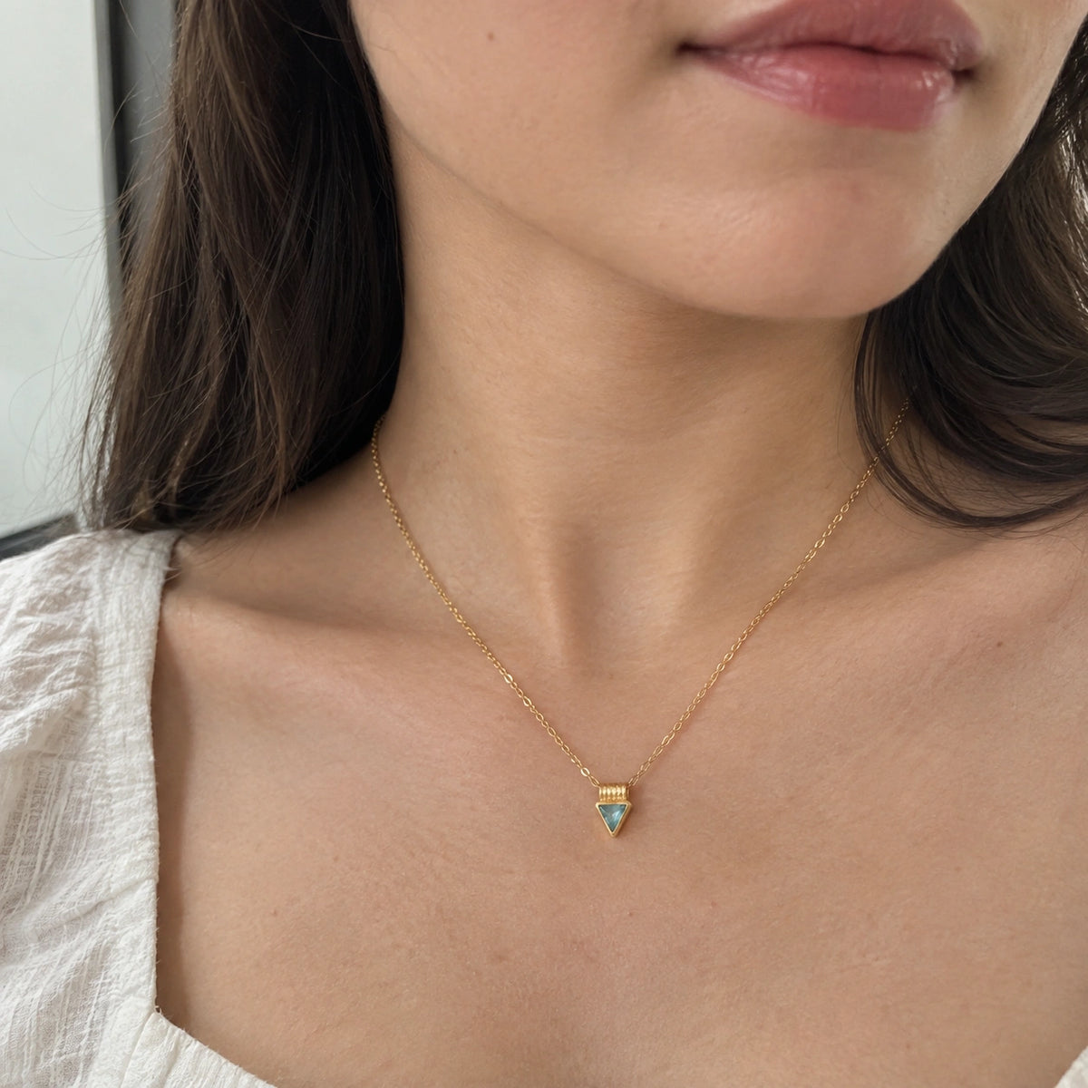 Aquamarine_necklace_in_gold_plated_silver_with_a_triangle_stone_worn_by_a_model