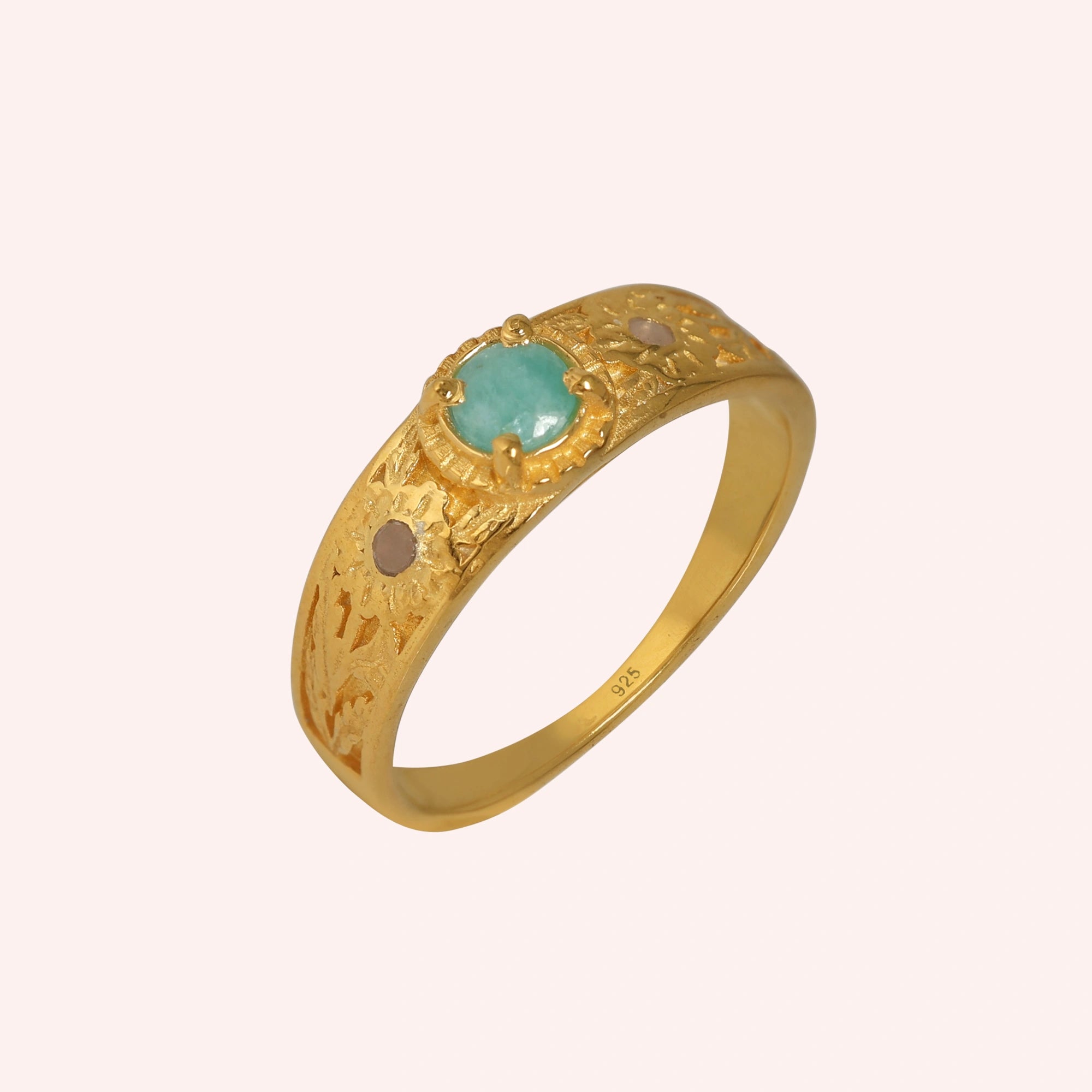 Art-deco-ring-in-gold-plated-silver-with-blue-center-stone-and-textured-band-side-angled-view-on-solid-pink-background