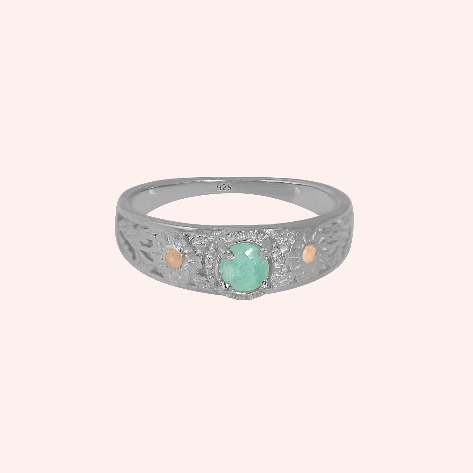 Art-deco-ring-in-sterling-silver-with-blue-center-stone-and-textured-band-front-angle-view-on-solid-pink-background