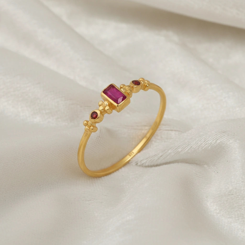 Baguette-ring-with-ruby-and-garnet-gemstones-gold-plated-silver-angled-view-on-white-satin-background