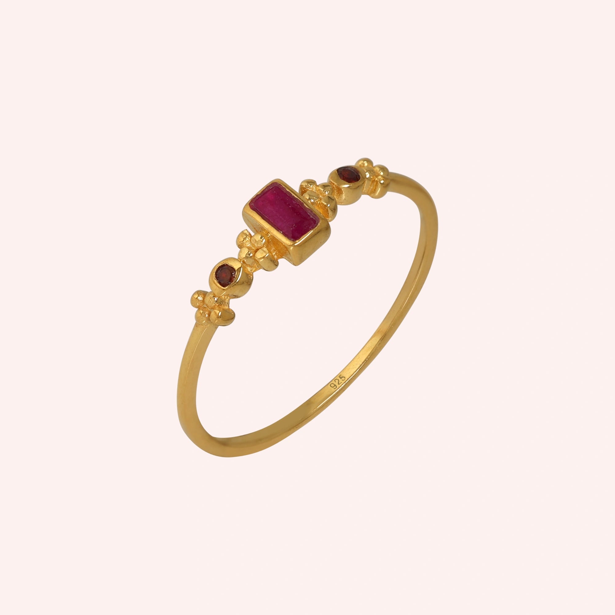 Baguette-ring-with-ruby-and-garnet-gemstones-gold-plated-silver-angled-view-on-soft-pink-background