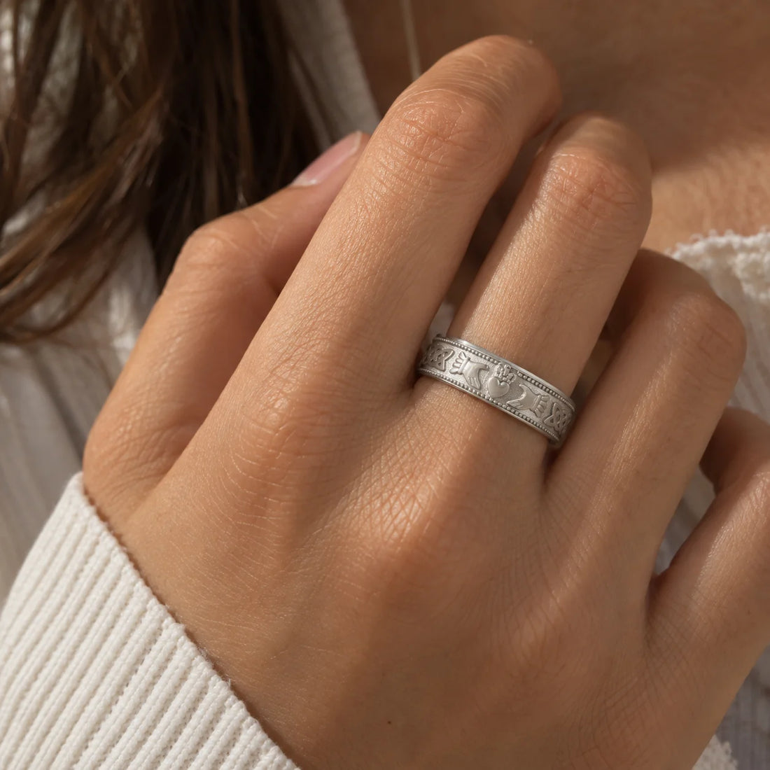 Band_ring_in_gold_plated_silver_with_claddagh_design_at_front_angle_view_on_soft_fabric_background