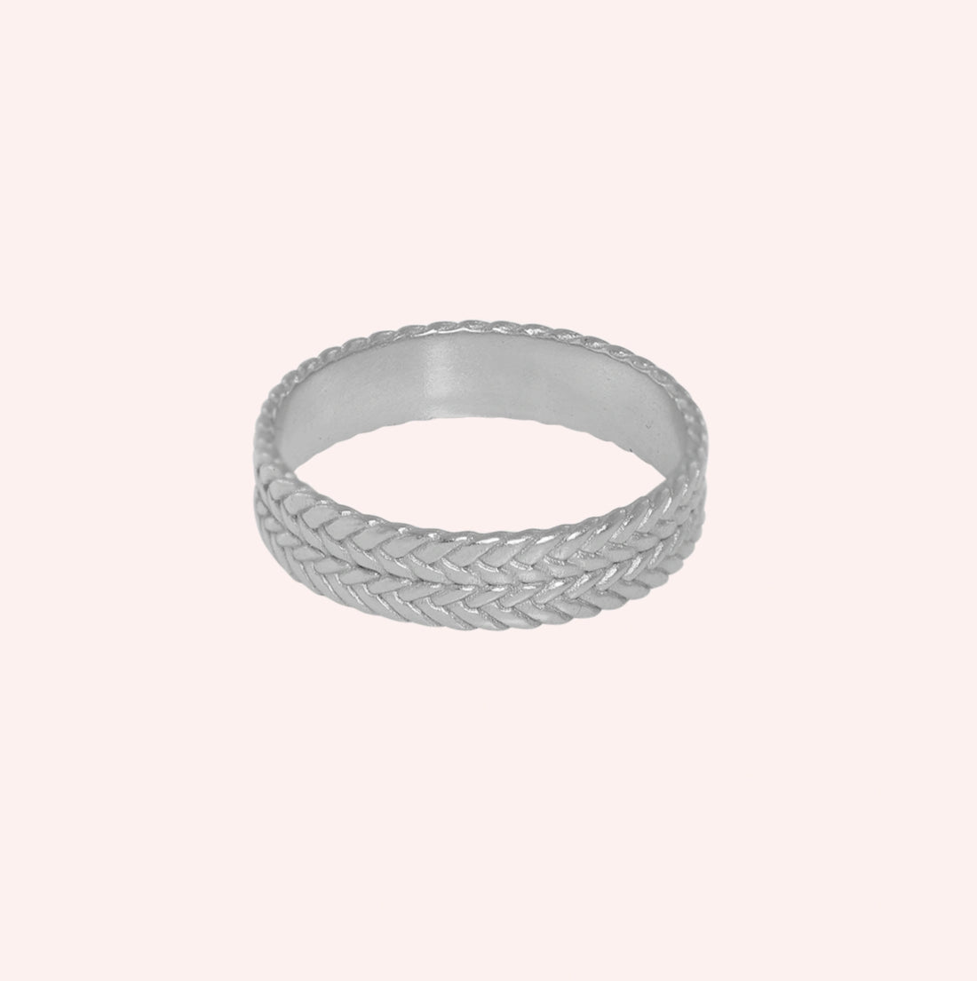 Band_ring_in_sterling_silver_with_braided_design_at_front_angle_on_solid_pink_background