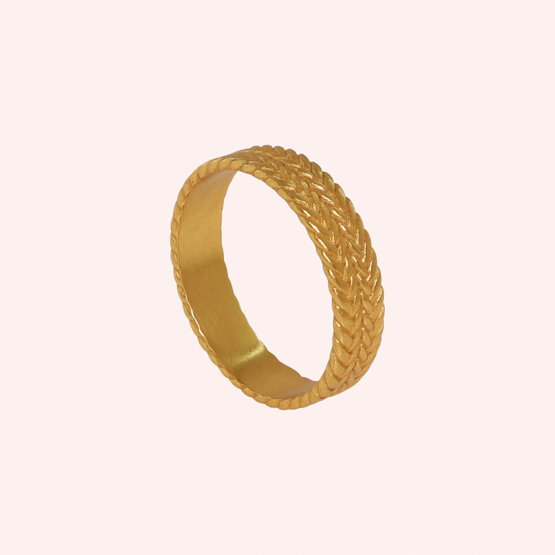 Band_ring_in_sterling_silver_with_braided_design_at_front_angle_on_solid_pink_background