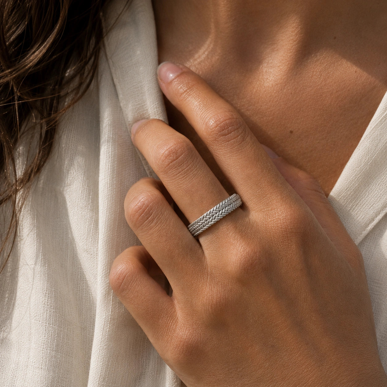 Band_ring_in_sterling_silver_with_braided_design_worn_by_a_model
