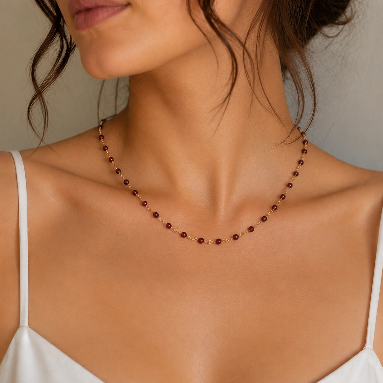 Beaded_necklace_with_gold_plated_silver_chain_and_deep_red_gemstone_beads_worn_by_a_model