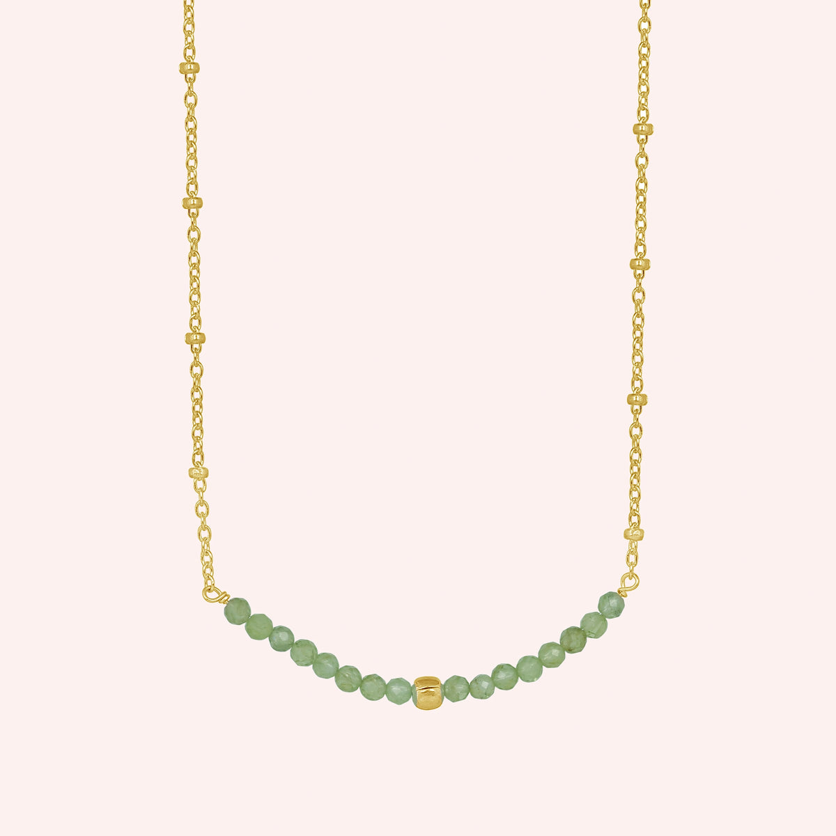 Peridot_necklace_in_gold_plated_silver_with_peridot_stones_in_beaded_design_in_front_angle_on_solid_pink_background