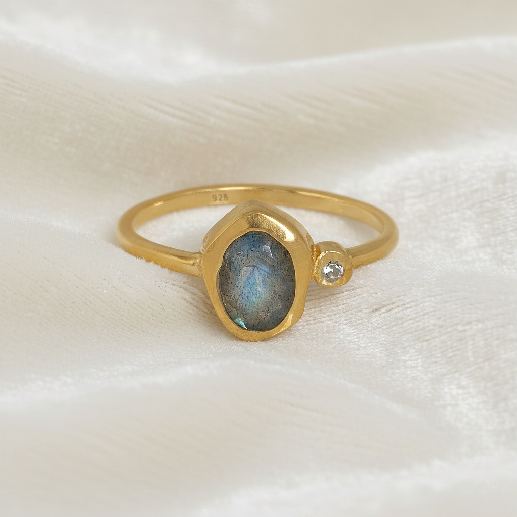 Bezel-set-ring-with-labradorite-and-white-topaz-stones-gold-plated-silver-front-view-on-satin-background