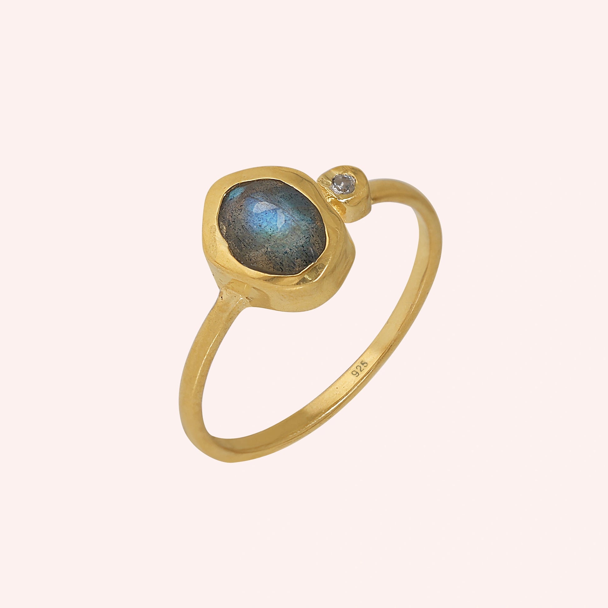 Bezel-set-ring-with-labradorite-and-white-topaz-stones-gold-plated-silver-angled-view-on-soft-pink-background