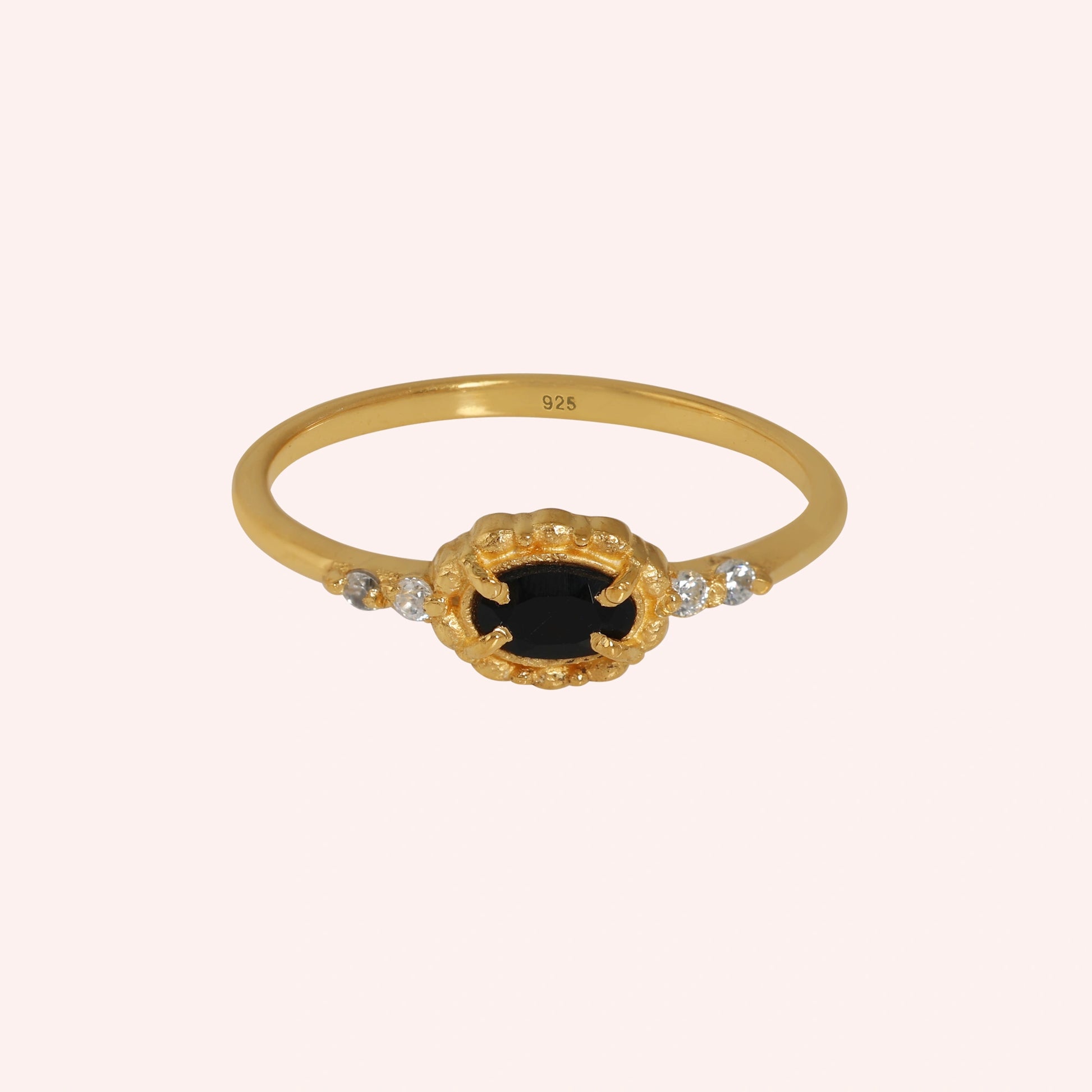 Black-onyx-ring-with-white-topaz-stones-gold-plated-silver-front-view-on-soft-pink-background