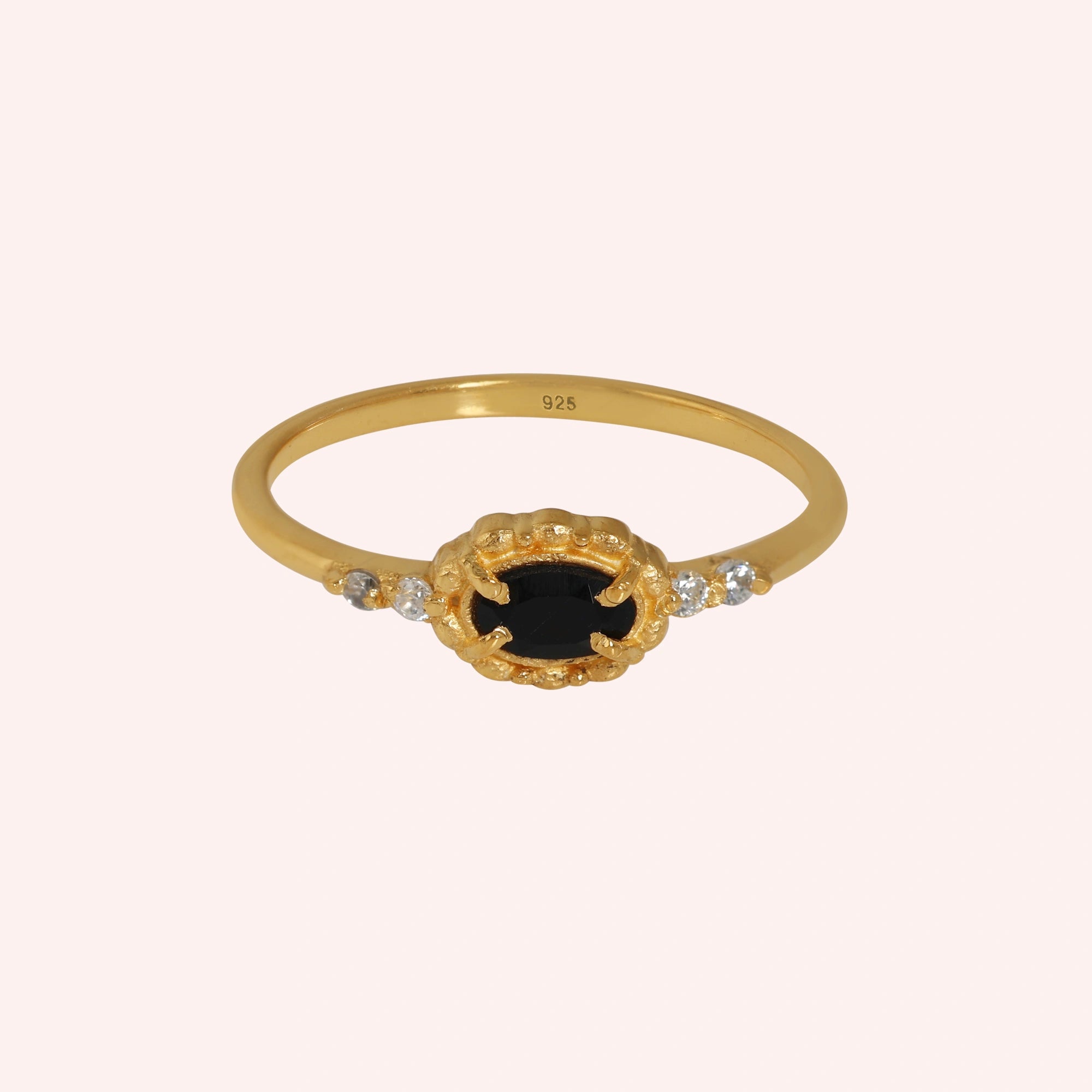 Black-onyx-ring-with-white-topaz-stones-gold-plated-silver-front-view-on-soft-pink-background