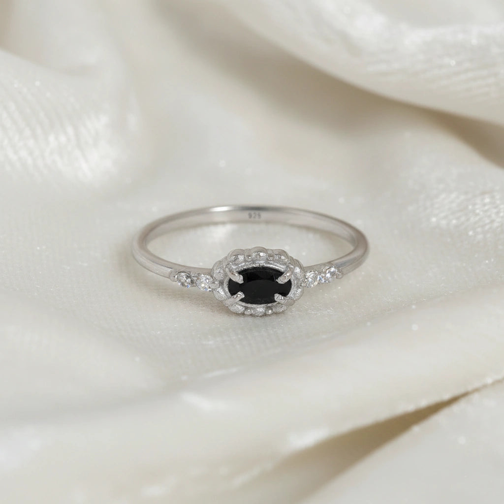 Black-onyx-ring-with-white-topaz-stones-sterling-silver-front-view-on-white-satin-background
