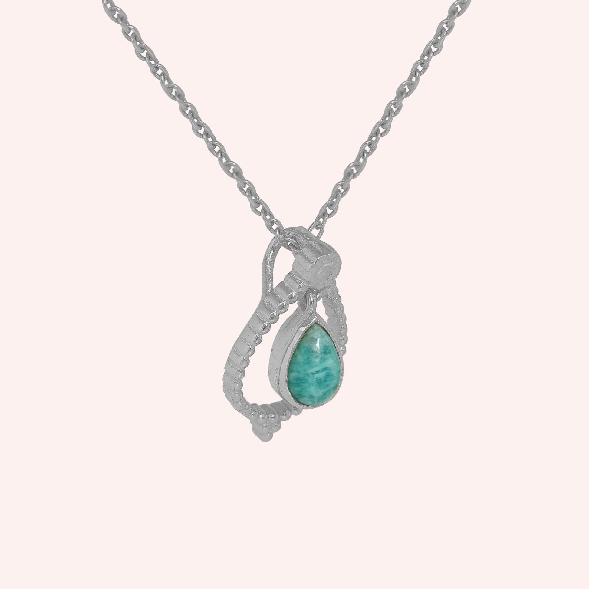 Blue_stone_necklace_in_sterling_silver_at_slight_angle_featuring_amazonite_stone_on_solid_pink_background