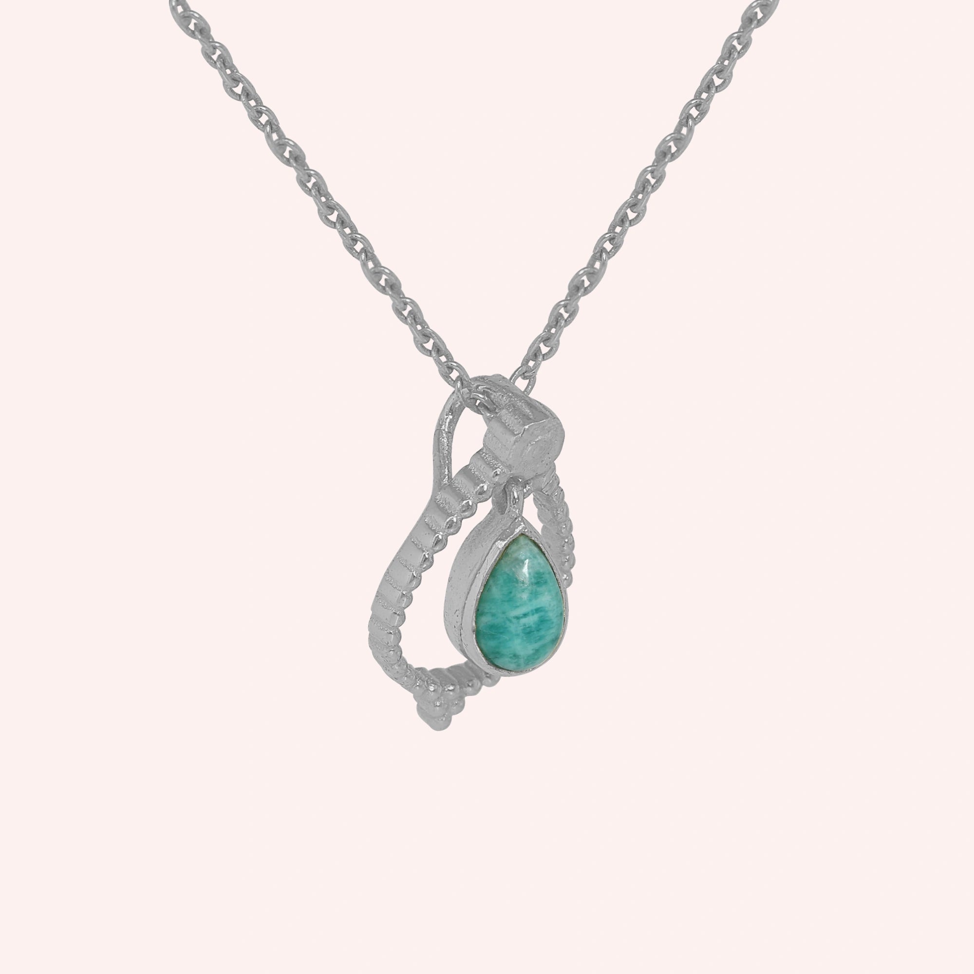 Blue_stone_necklace_in_sterling_silver_at_slight_angle_featuring_amazonite_stone_on_solid_pink_background