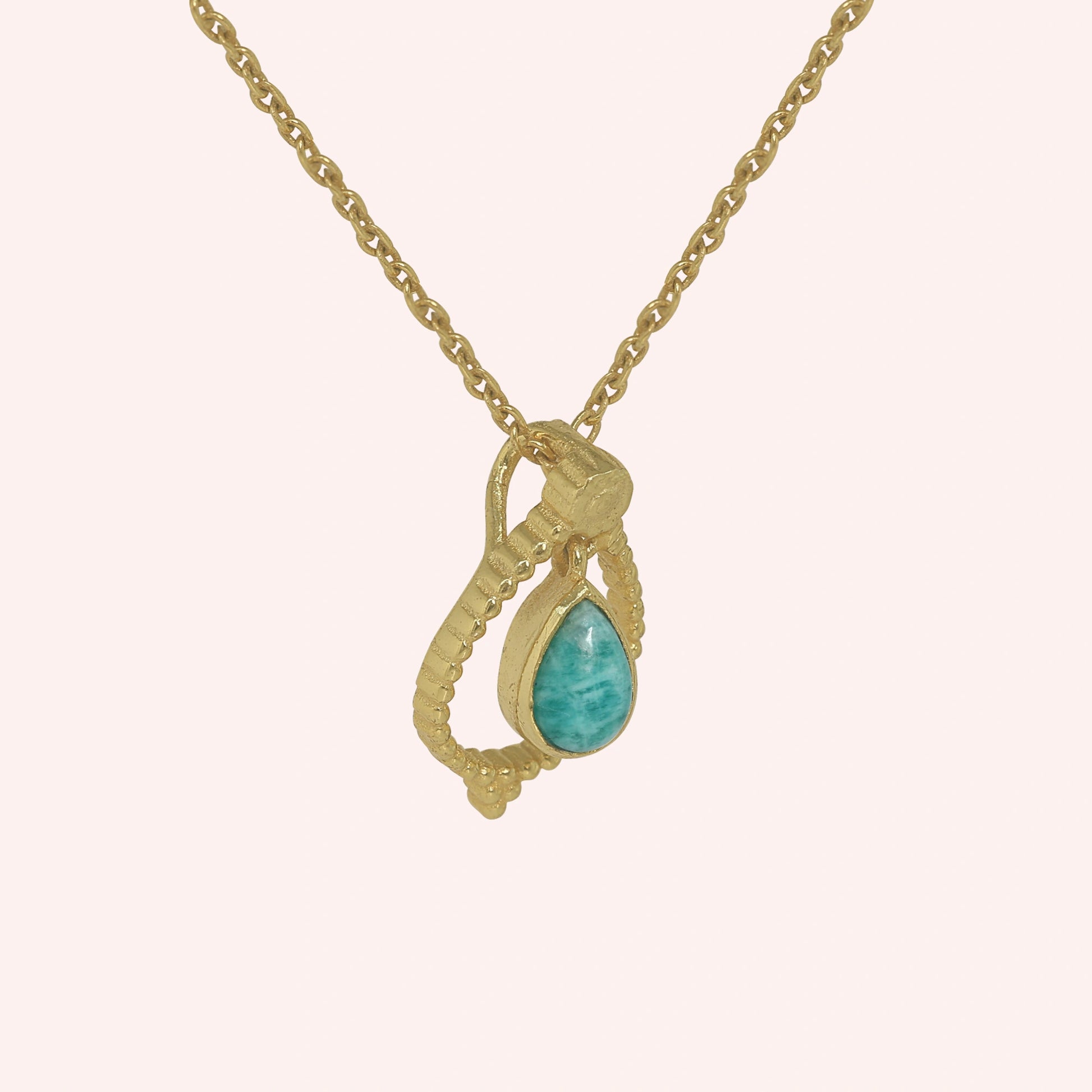 Blue_stone_necklace_in_gold_plated_silver_at_slight_angle_featuring_amazonite_stone_on_solid_pink_background
