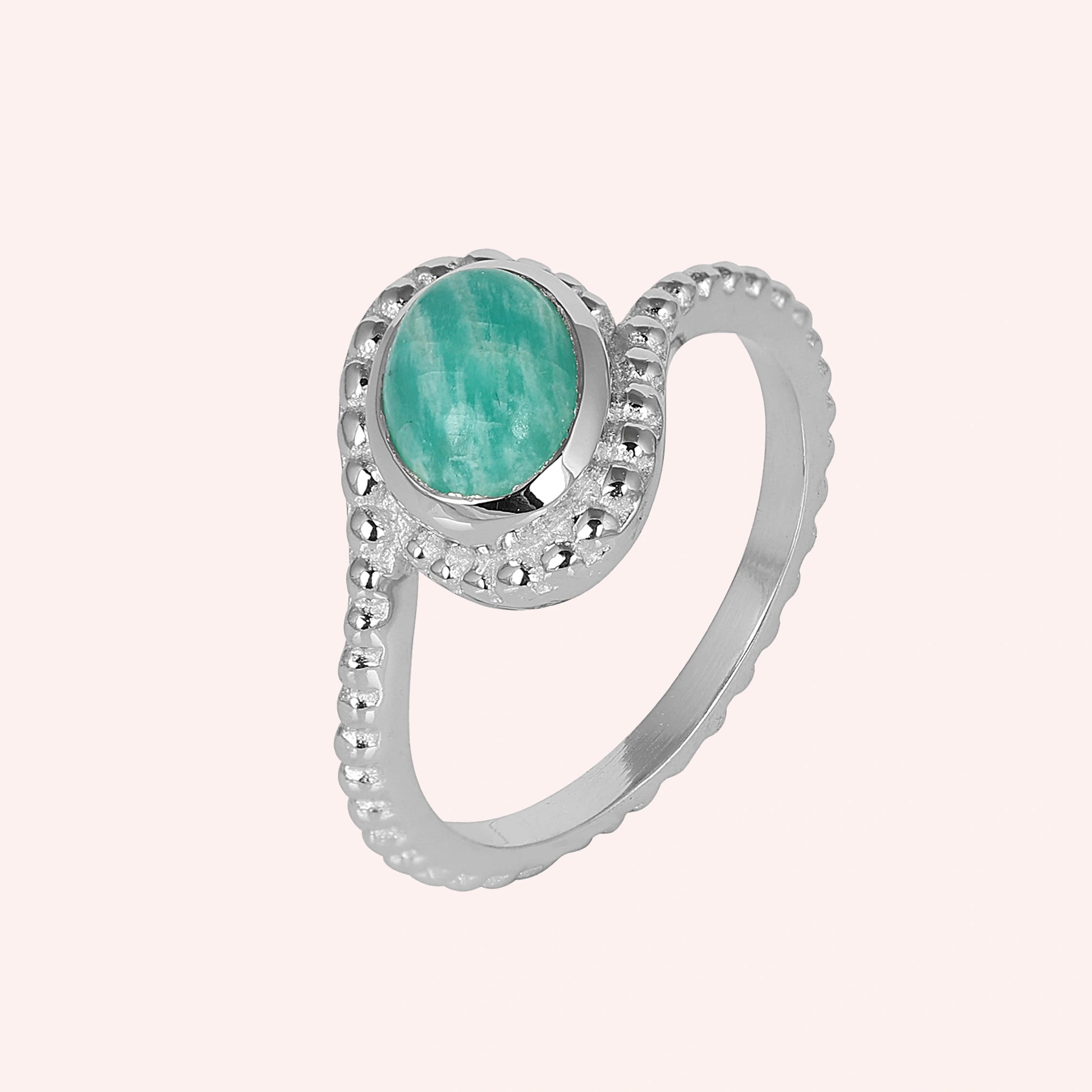 Blue_stone_ring_in_sterling_silver_with_an_oval_amazonite_stone_at_slight_angle_view_on_solid_pink_background