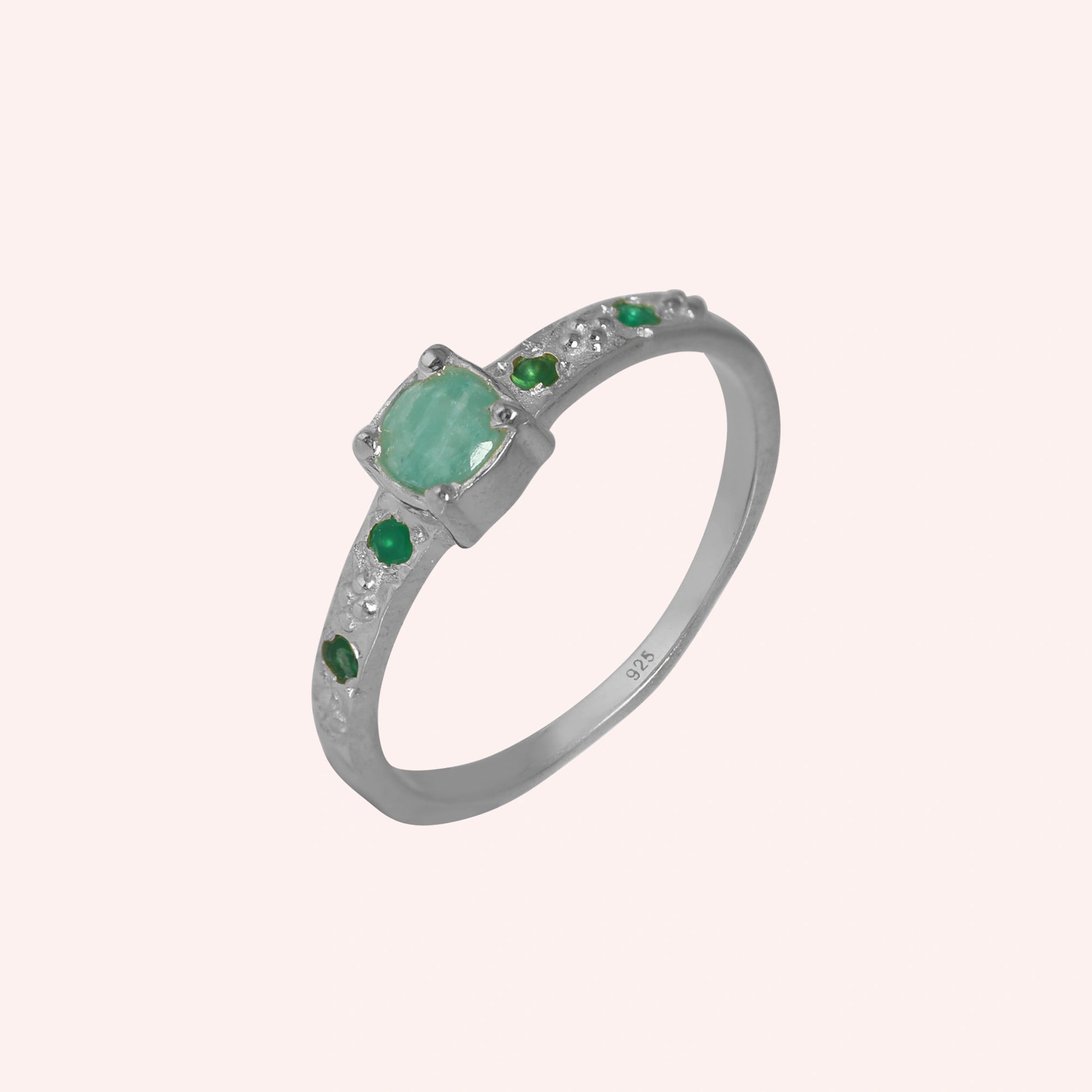 Blue-stone-ring-in-sterling-silver-with-green-stones-in-angled-side-view-on-soft-pink-background
