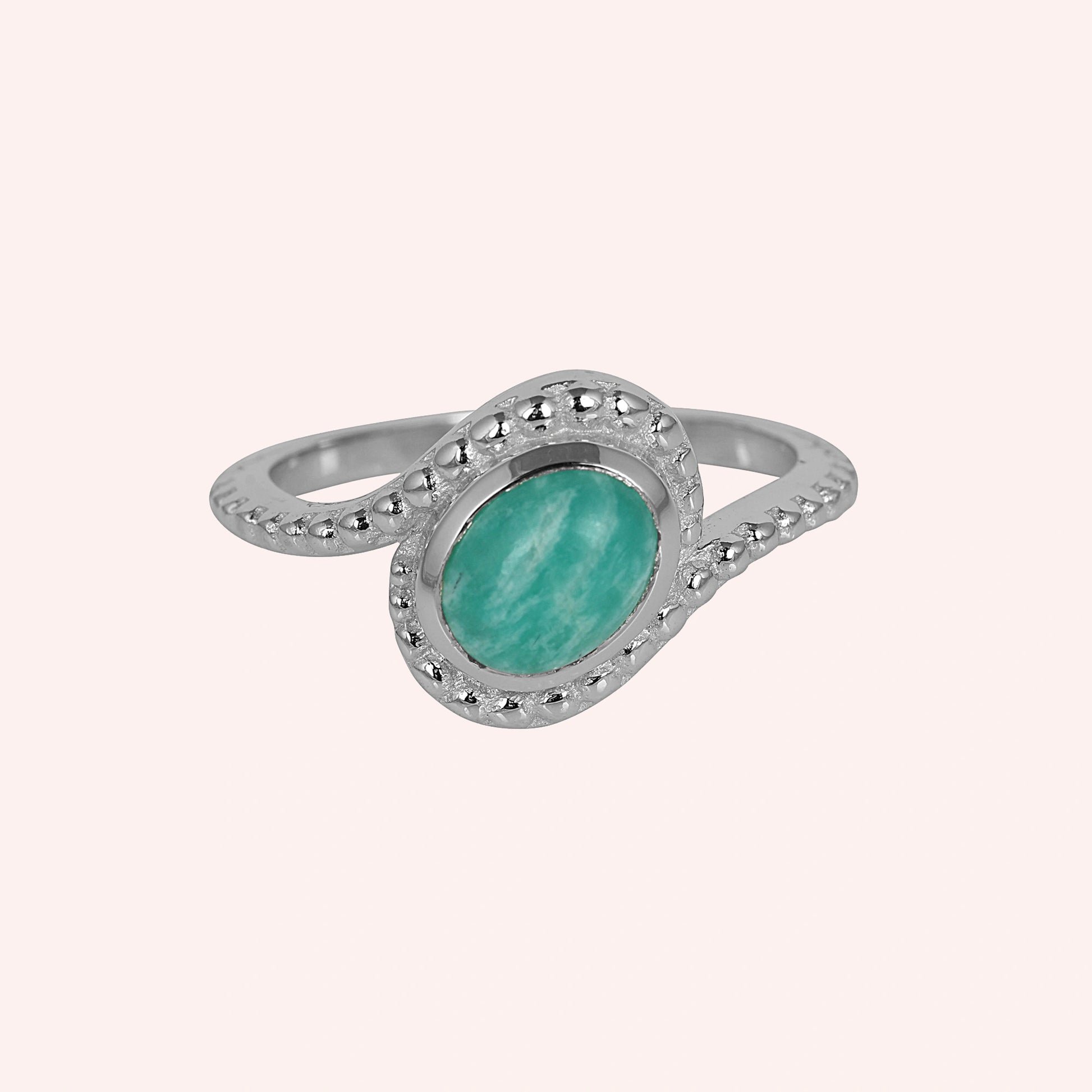 Blue_stone_ring_in_sterling_silver_with_an_oval_amazonite_stone_at_front_angle_view_on_solid_pink_background