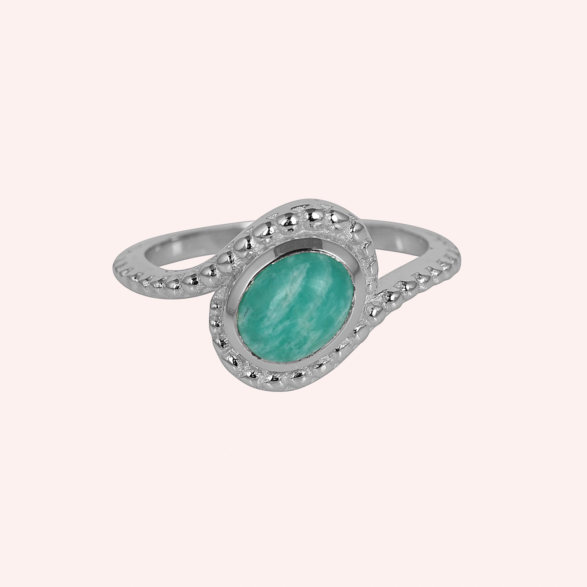 Blue_stone_ring_in_sterling_silver_with_an_oval_amazonite_stone_at_front_angle_view_on_solid_pink_background