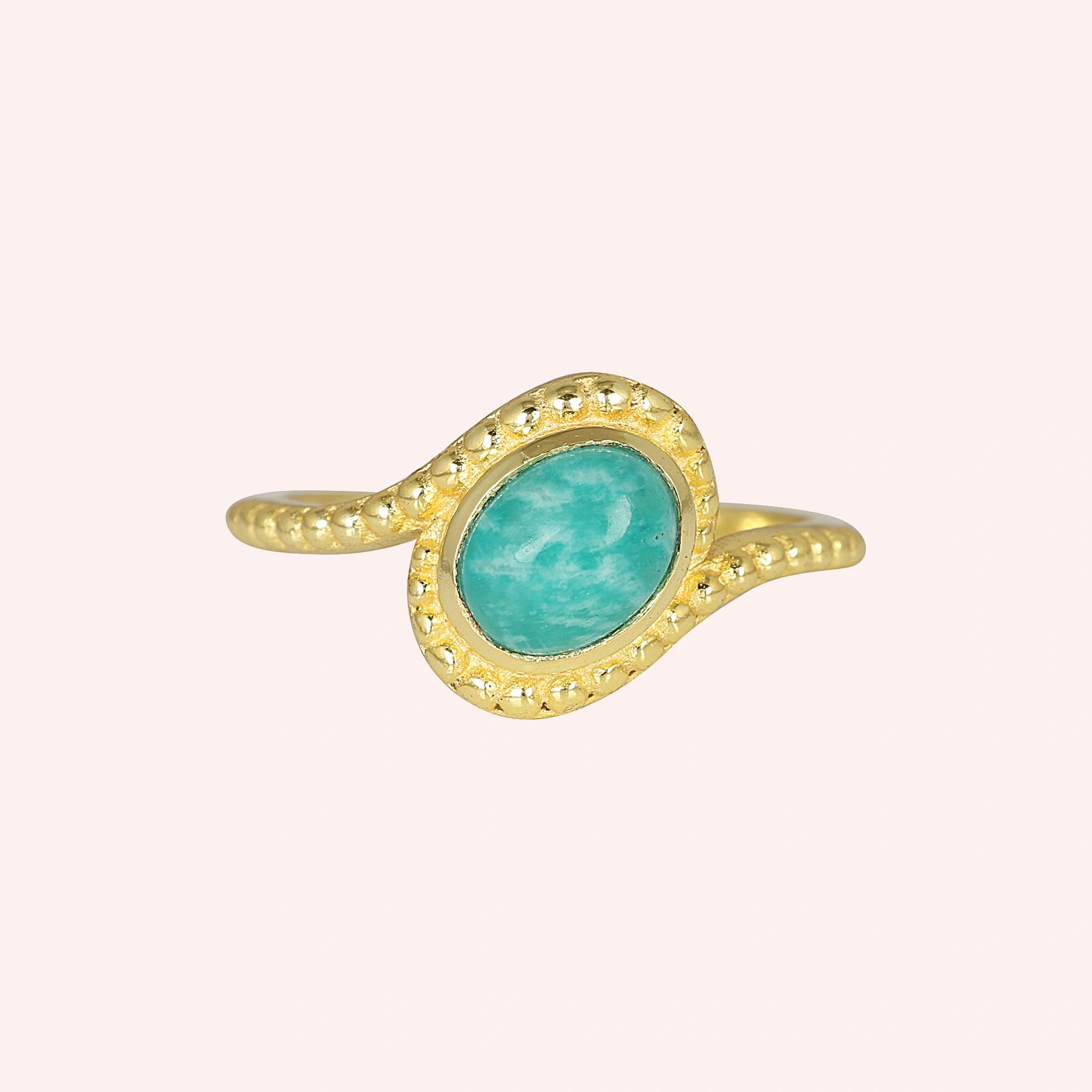Blue_stone_ring_in_gold_plated_silver_with_an_oval_amazonite_stone_at_front_angle_view_on_solid_pink_background