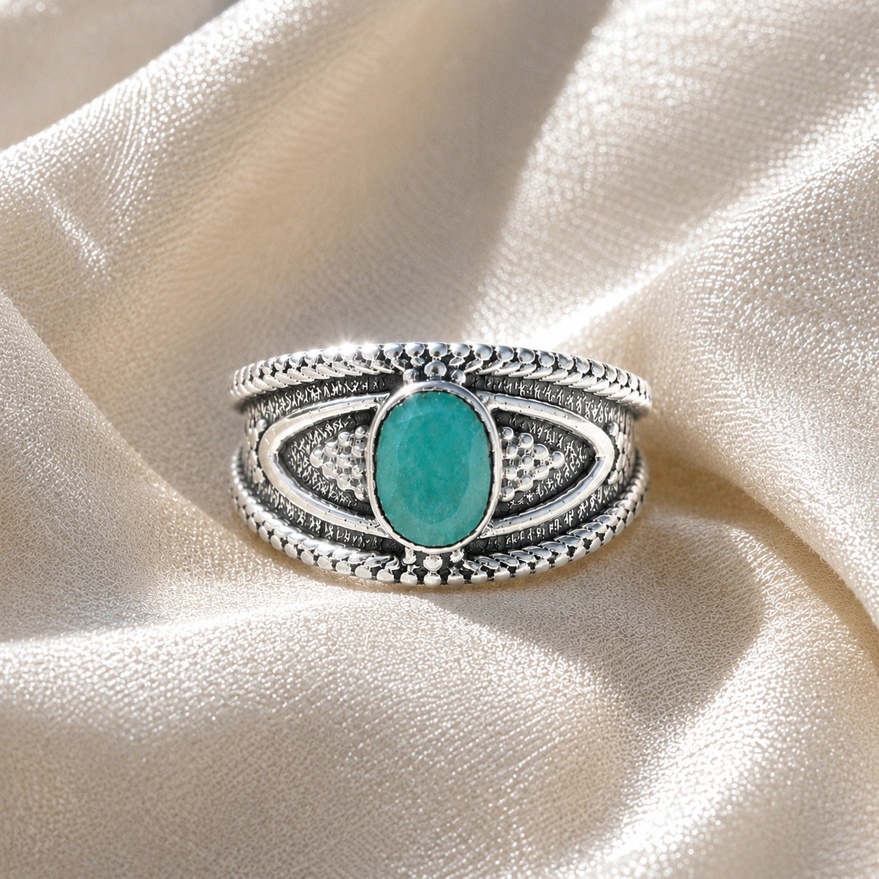 Boho_ring_with_amazonite_stone_sterling_silver_with_filigree_texture_in_front_angle_view_on_soft_fabric_background
