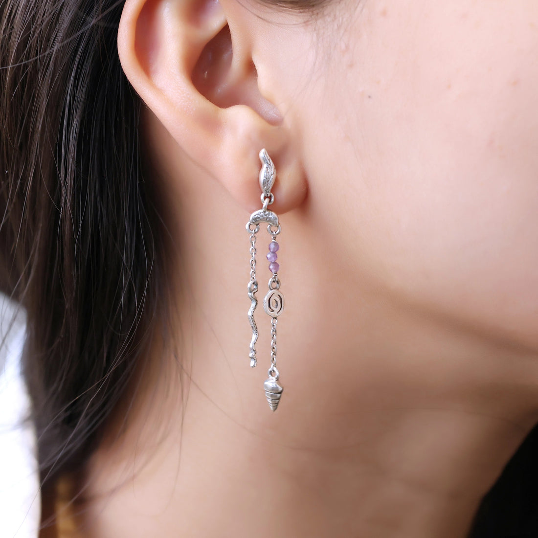 front_angle_boho_silver_earrings_with_purple_beads_and_shell_drops_showing_lightweight_earrings_on_soft_white_fabric_cloth