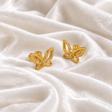 Butterfly_earrings_in_gold_plated_silver_in_a_stud_design_at_side_angle_view_on_soft_fabric_background
