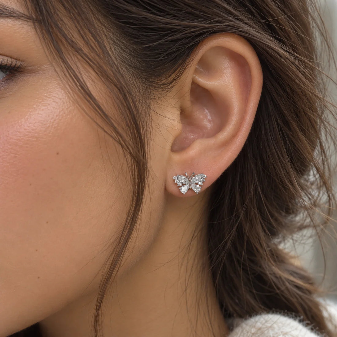 Diamond_butterfly_earrings_in_gold_plated_silver_with_lab_grown_diamonds_at_side_angle_view_on_soft_fabric_background