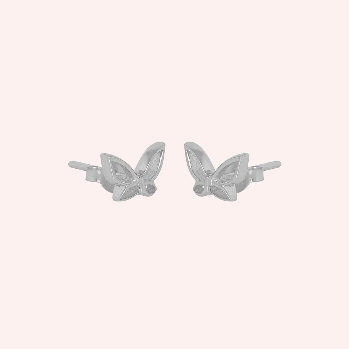 Butterfly_earrings_in_sterling_silver_in_a_stud_design_at_side_angle_view_on_solid_pink_background