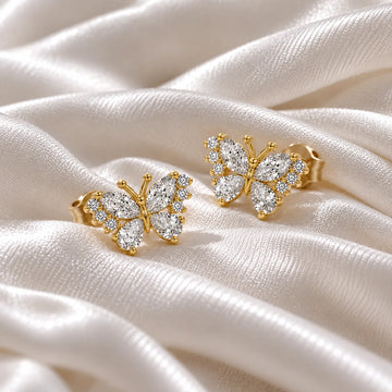 Diamond_butterfly_earrings_in_gold_plated_silver_with_lab_grown_diamonds_at_side_angle_view_on_soft_fabric_background