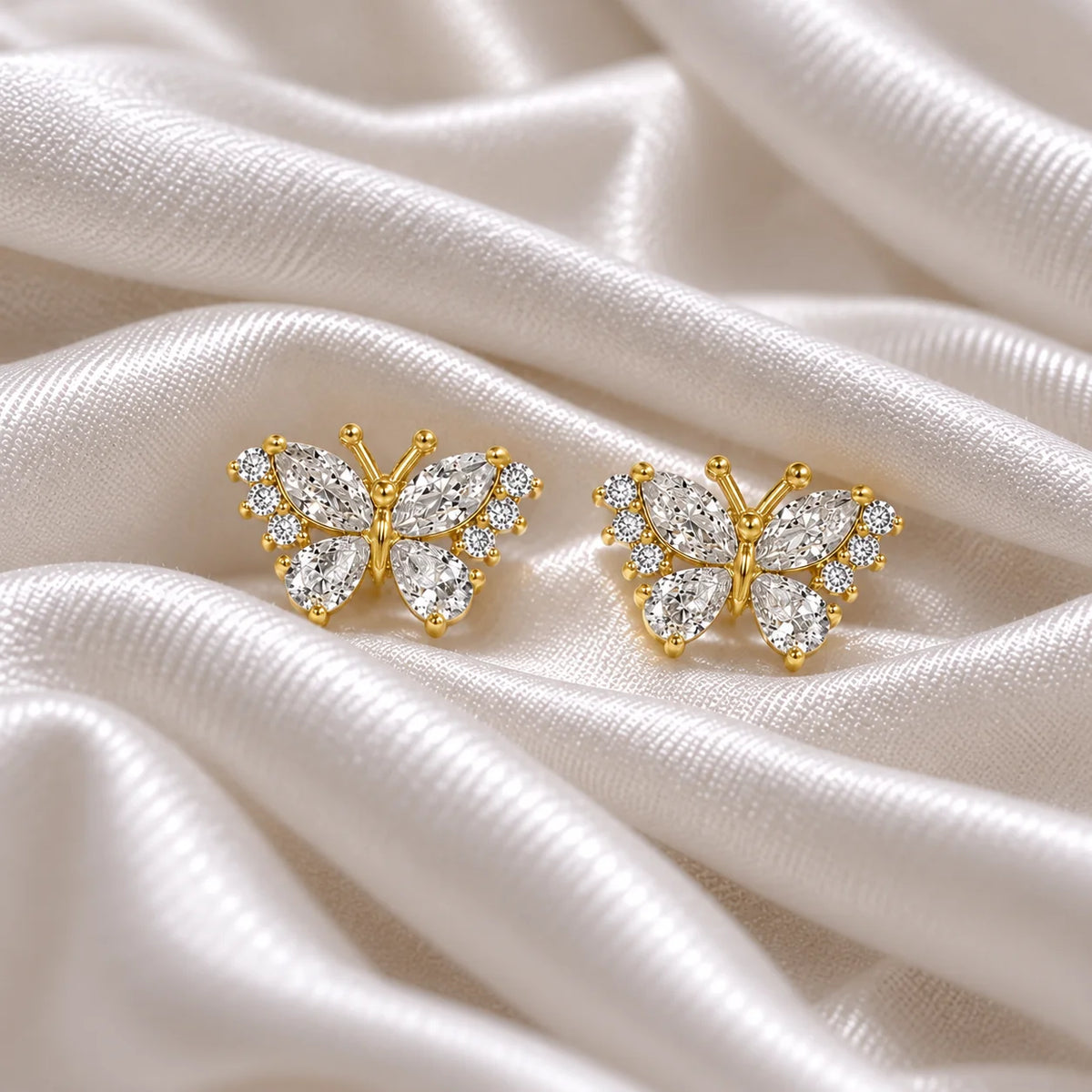 Diamond_butterfly_earrings_in_gold_plated_silver_with_lab_grown_diamonds_at_front_angle_view_on_soft_fabric_background