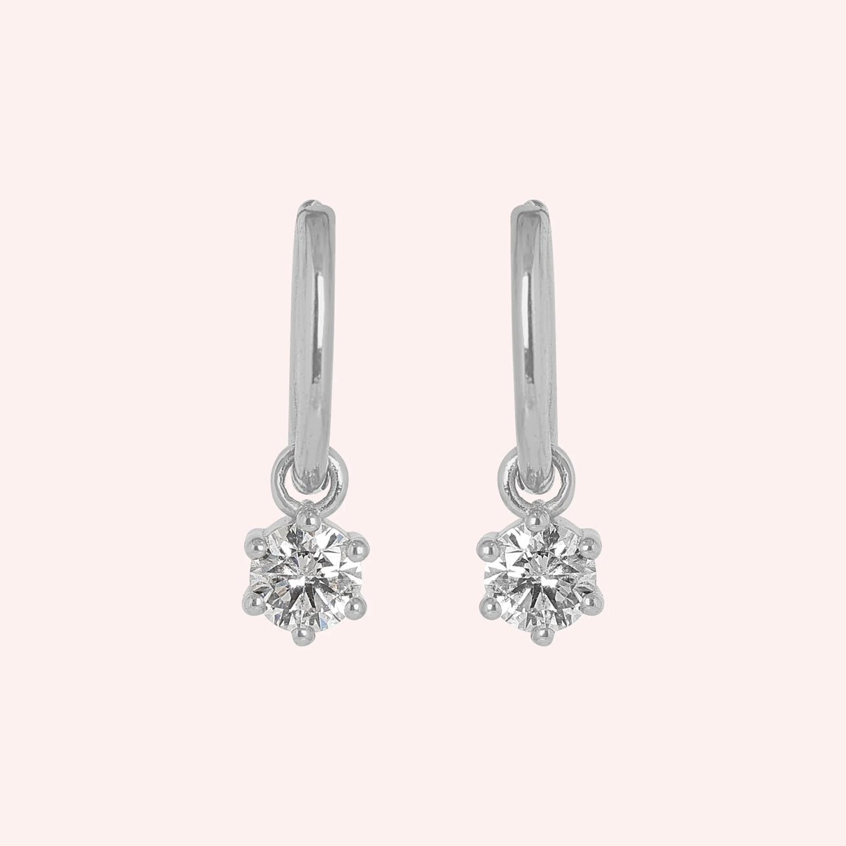 CZ_earrings_in_sterling_silver_with_a_hoop_drop_design_at_front_angle_view_on_solid_pink_background
