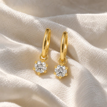 CZ_earrings_in_gold_plated_silver_with_a_hoop_drop_design_at_front_angle_view_on_soft_fabric_background