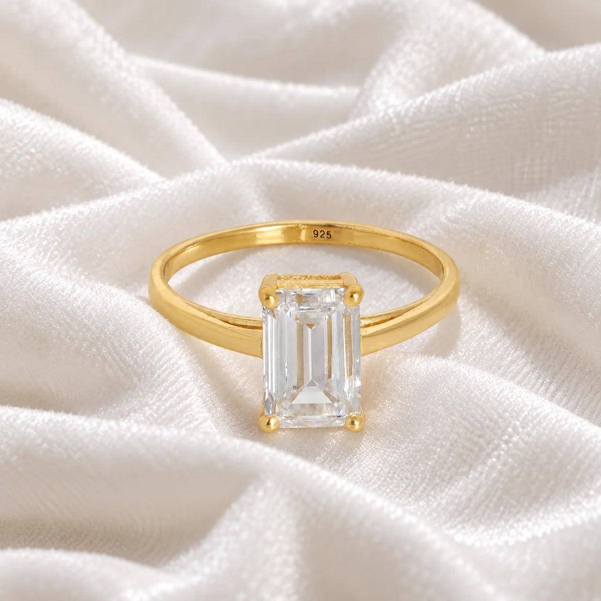 CZ_ring_in_gold_plated_silver_with_a_baguette_shaped_CZ_at_front_view_on_soft_fabric_background