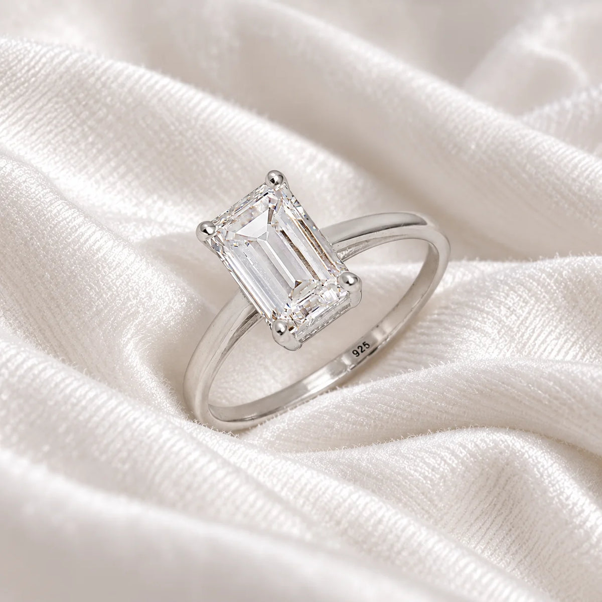 CZ_ring_in_sterling_silver_with_a_baguette_shaped_CZ_at_side_view_on_soft_fabric_background