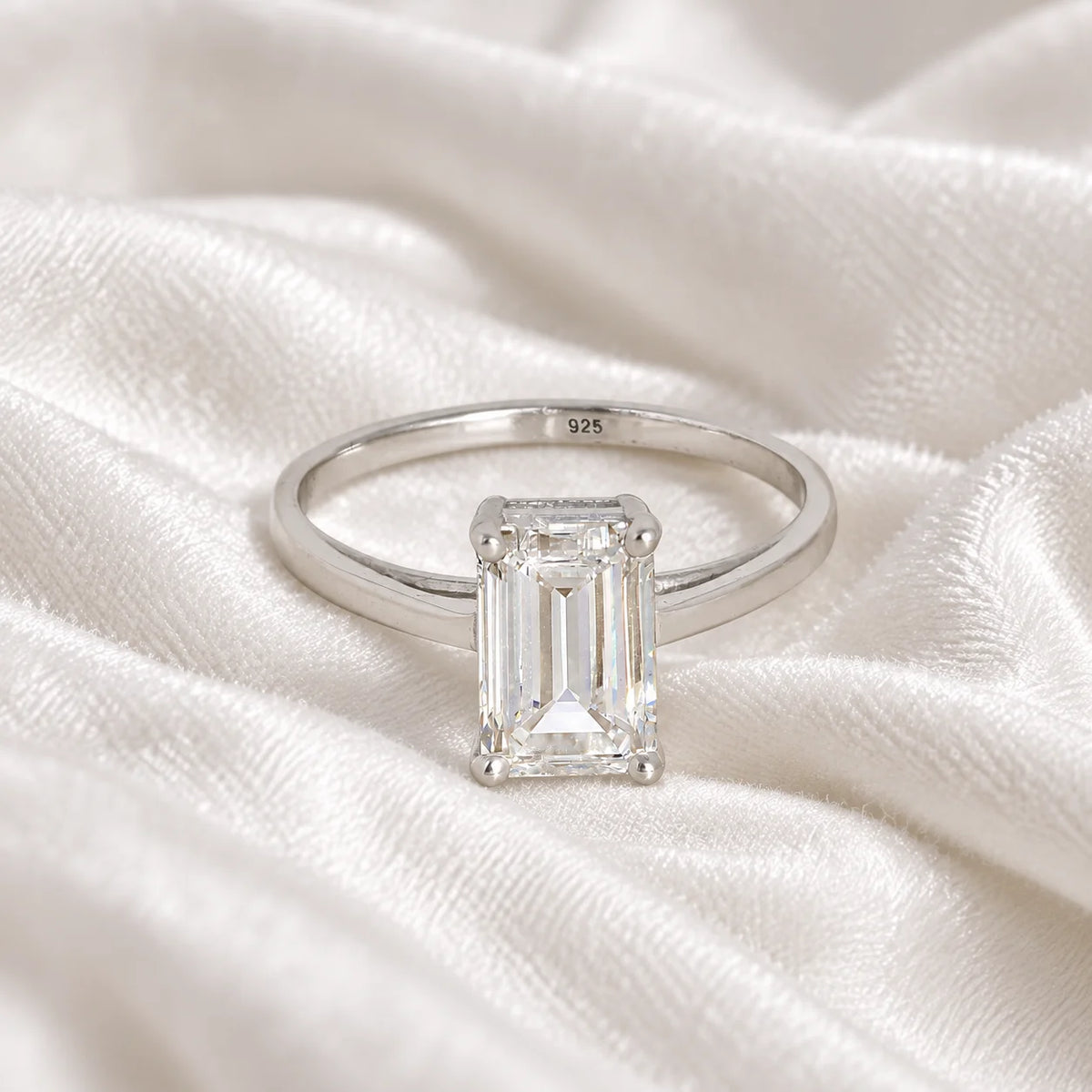 CZ_ring_in_sterling_silver_with_a_baguette_shaped_CZ_at_front_view_on_soft_fabric_background
