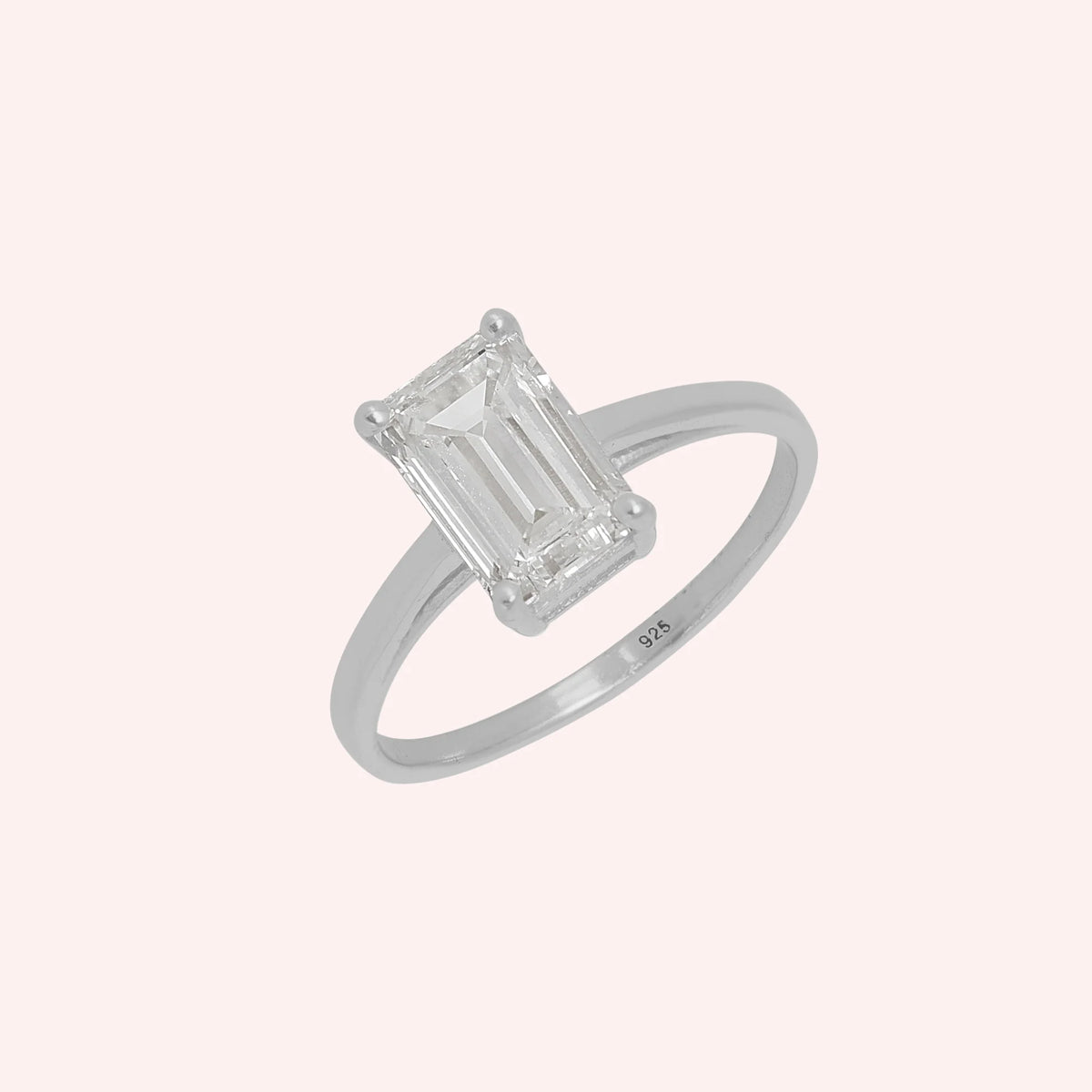 CZ_ring_in_sterling_silver_with_a_baguette_shaped_CZ_at_side_view_on_solid_pink_background