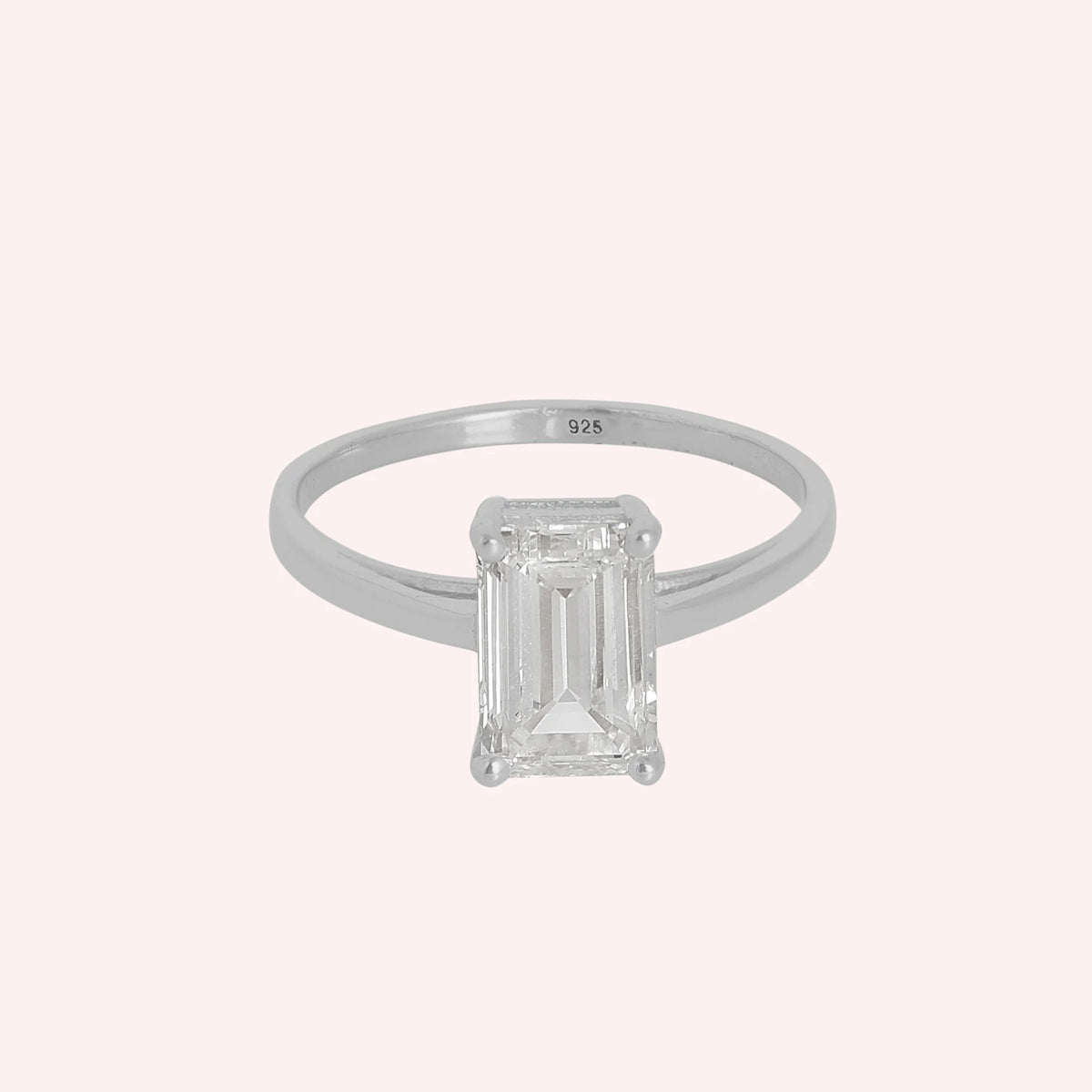 CZ_ring_in_sterling_silver_with_a_baguette_shaped_CZ_at_front_view_on_solid_pink_background